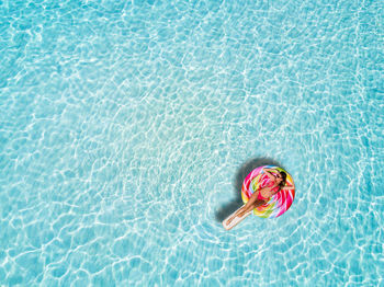 Woman relaxing in inflatable ring over sea