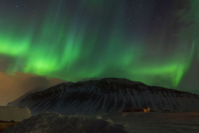 Scenic view of snowcapped mountain against sky at night