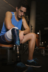 Young man looking away while sitting on seat