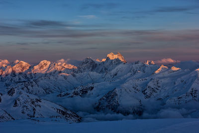 Scenic view of snow mountains against sky during sunset