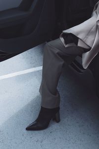 Low section of woman in high heels sitting in car