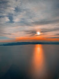 Scenic view of sea against dramatic sky during sunset