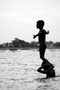 Side view of boy on beach against sky