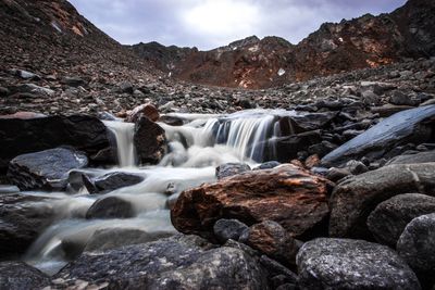 Scenic view of waterfall against sky