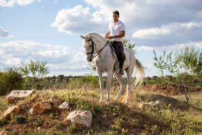 Man riding horse against sky