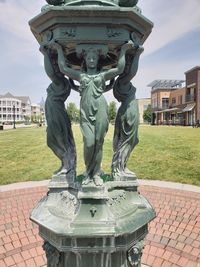 Statue in park against sky in city