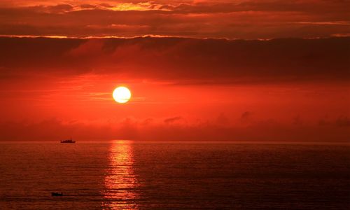 Scenic view of sea against orange sky