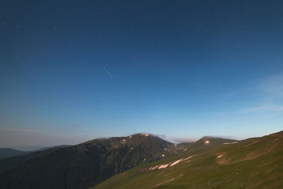 Scenic view of mountains against sky at night