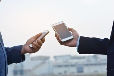 Midsection of man using mobile phone