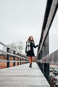 Full length of woman standing on footbridge