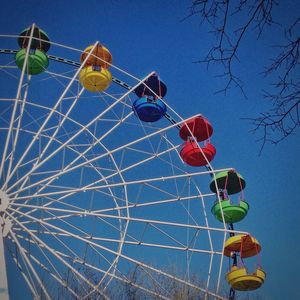 Low angle view of ferris wheel against blue sky