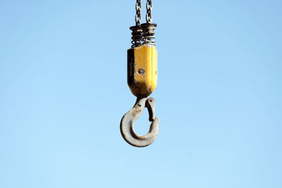Low angle view of chain against blue sky