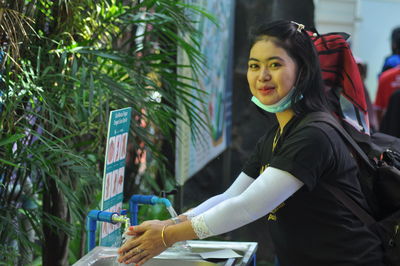 Side view of a young woman washing hand at sink