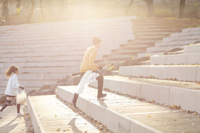 Rear view of couple walking on staircase