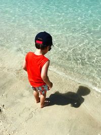 High angle view of boy standing on shore at beach during summer