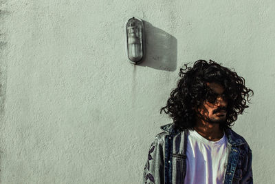 Portrait of man standing against wall