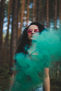 Portrait of woman wearing sunglasses in forest