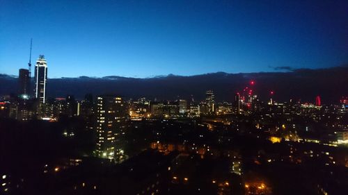 Illuminated city against sky at night