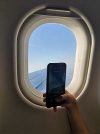 Man photographing through airplane window