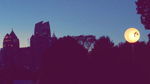 Low angle view of illuminated street light against sky