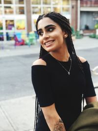 Fashionable smiling young woman in city