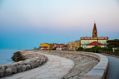 Footpath amidst buildings against sky