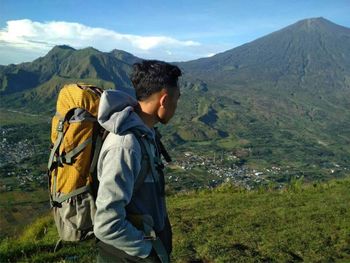 Side view of man standing against mountains 