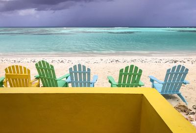 Chairs on beach against sky