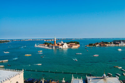 Church of san giorgio maggiore amidst canal against clear blue sky on sunny day