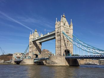 View of bridge over river against blue sky