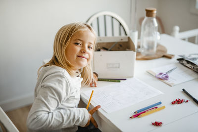 Smiling girl at home doing homework