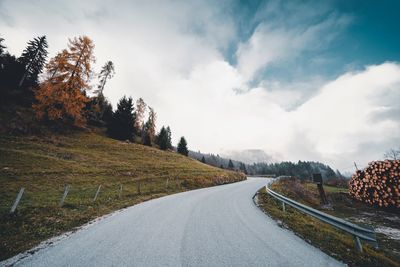 Road amidst trees against sky