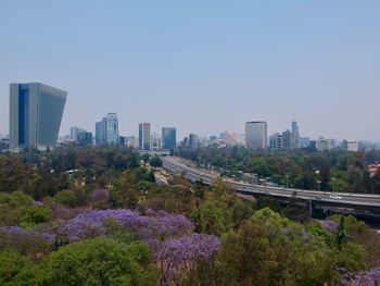 View of city buildings against clear sky