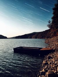 Scenic view of lake by mountains against clear sky