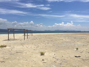 Surface level of sandy beach against blue sky