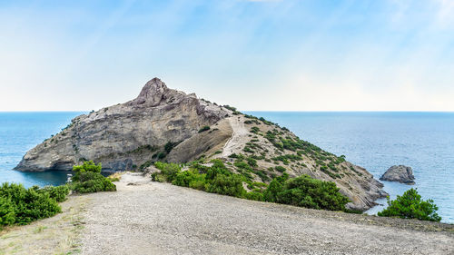 Scenic view of rocks on beach against sky