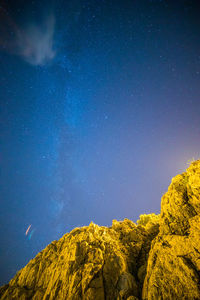 Low angle view of mountain against sky at night with milky way