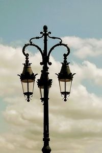 Low angle view of street light against cloudy sky