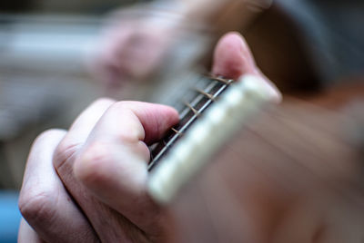 Close-up of hands of a man playing guitar