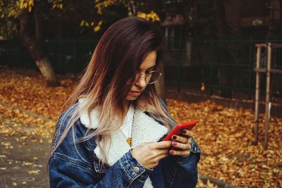 Teenage girl using mobile phone at park
