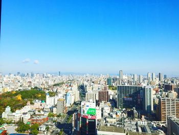 High angle shot of cityscape against blue sky