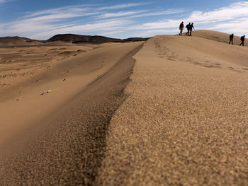 People walking on sand dune in desert