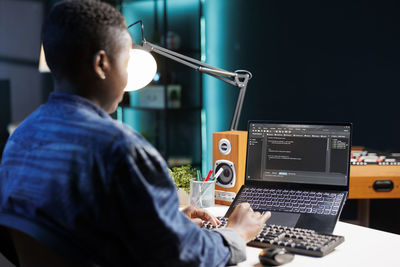 Side view of man using laptop