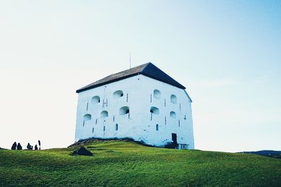 Building on field against clear sky