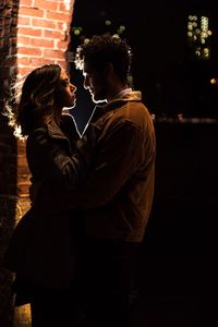 Side view of couple kissing against blurred background
