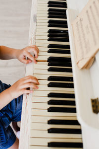 Midsection of girl playing piano