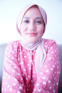 Portrait of young woman against white background