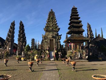 People at temple against sky