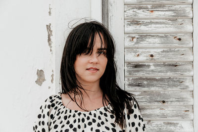 Portrait of beautiful woman standing against wall