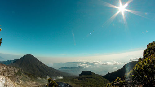 Scenic view of mountains against blue sky